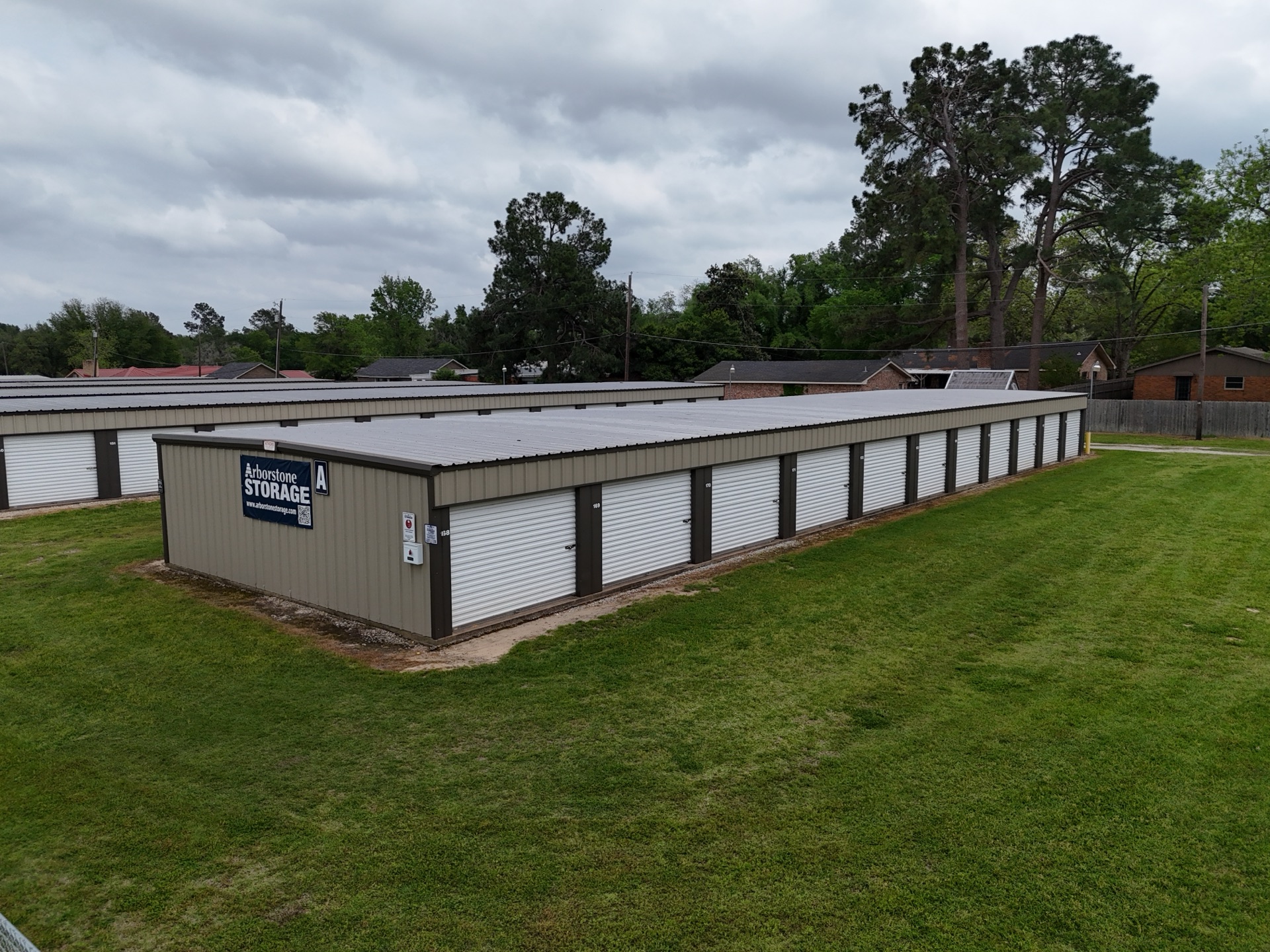 Arborstone Storage Teague I — tan metal drive-up storage building with green metal roof and Arborstone Storage signage, on a grassy lot in Teague, Freestone County, Texas.