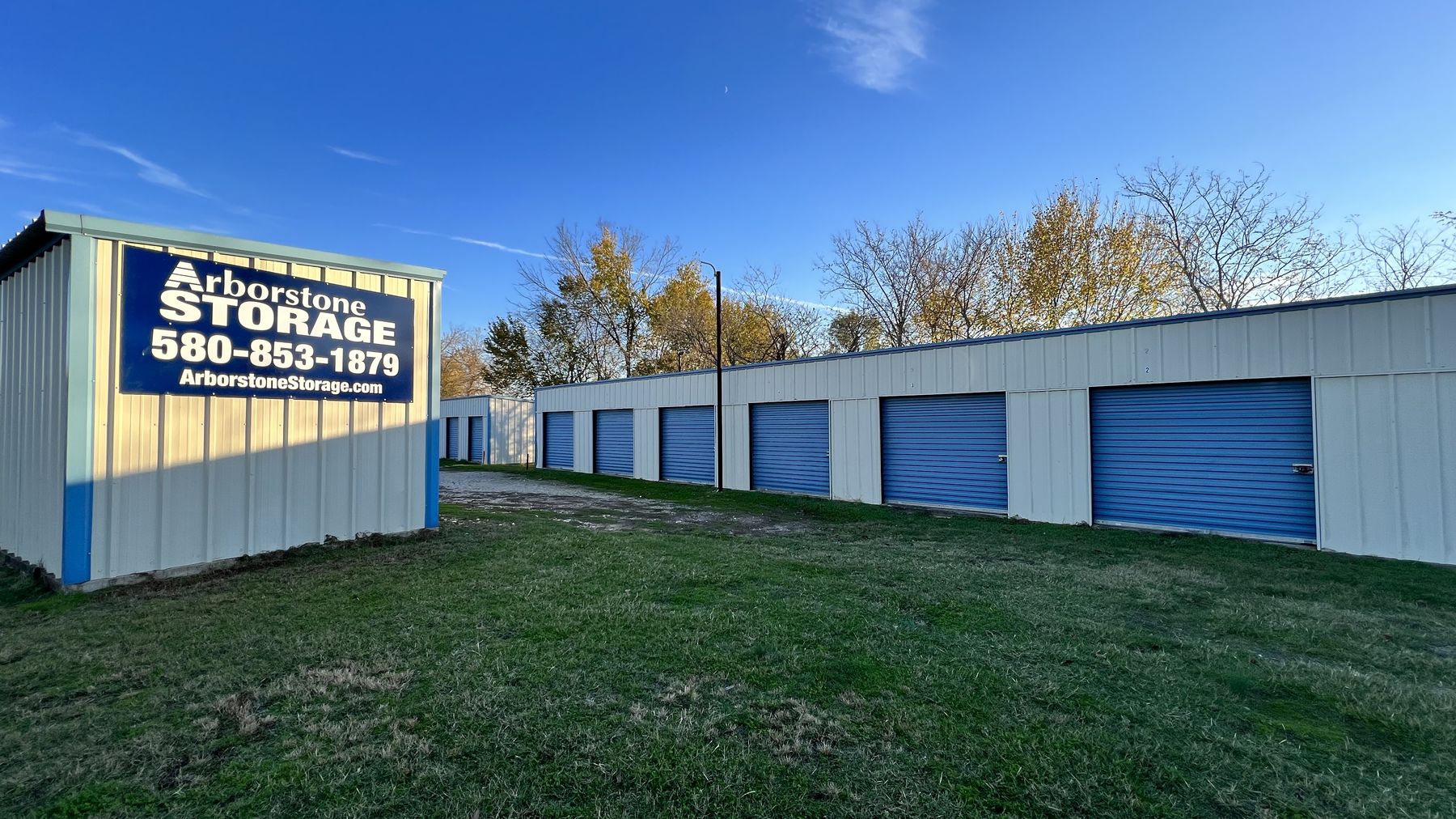 Arborstone Storage Hugo: the Arborstone Storage sign on the end of a white storage building beside a row of blue drive-up doors.