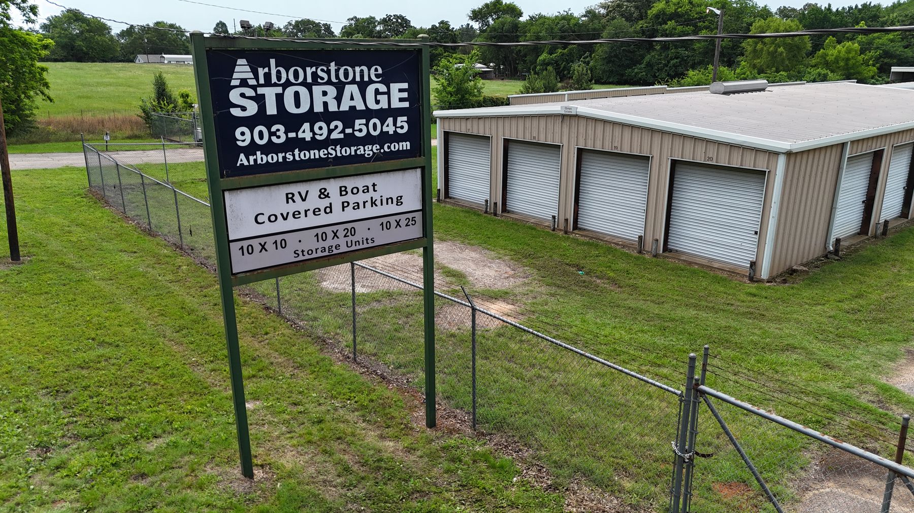Arborstone Storage Quitman: the Arborstone Storage sign advertising RV and boat covered parking beside a tan storage building with white roll-up doors.