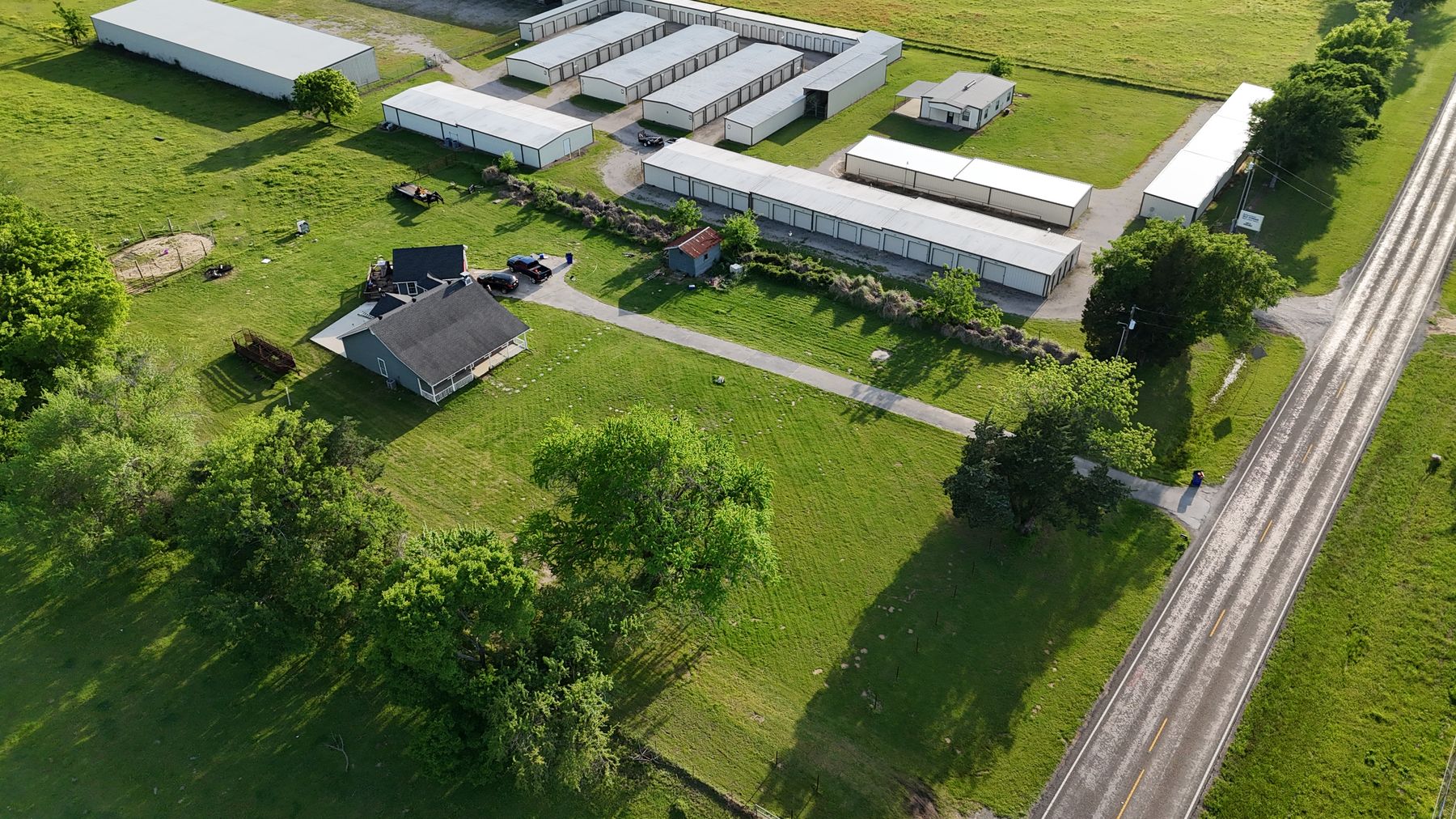 Aerial view of Arborstone Storage Van: rows of white storage buildings and covered parking on a green lot beside N Hwy 110.