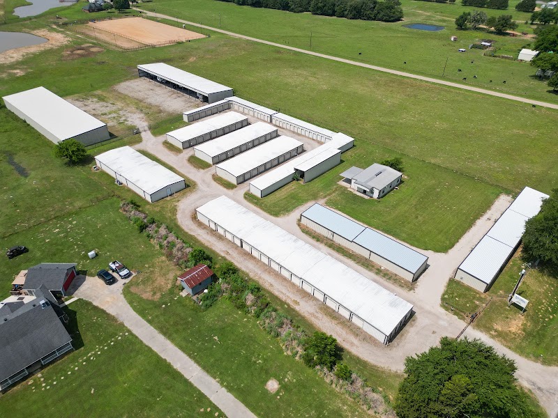 Aerial view of Arborstone Storage Van: rows of white storage buildings and covered parking on a green lot beside N Hwy 110.